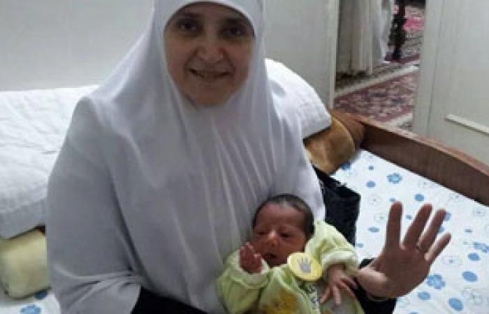 نجل الرئيس المعزول ينشر صورة والدته تحمل حفيدها وترفع إشارة رابعة