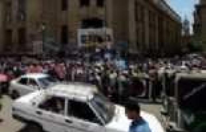 مجندو الأمن المركزي يلوحون بإشارات خارجة للمتظاهرين من شرفات دار القضاء