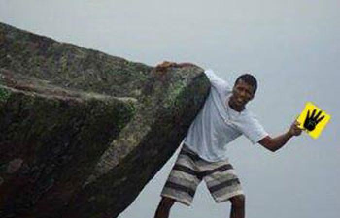 نشطاء يتداولون صورة مزيفة لشخص يتدلى من أعلى جبل يحمل شعار رابعة
