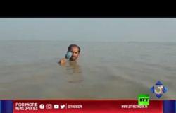 مراسل يخاطر بحياته ويغطي كارثة فيضان من تحت المياه