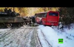 دبابة روسية تسحب حافلة علقت في طريق جليدي