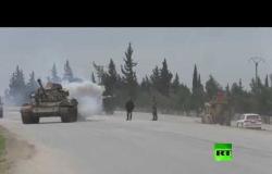 دورية روسية تركية تمر أمام قوات الجيش السوري