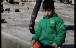 في يد دمية وبالأخرى كيس "تشيبس".. بالفيديو : مشهد مؤلم لطفل سوري وسط الركام